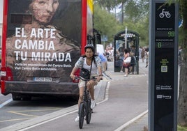 Una mujer se desplaza por un carril bici junto al tótem que contabiliza las bicicletas que pasan por ElSardinero.