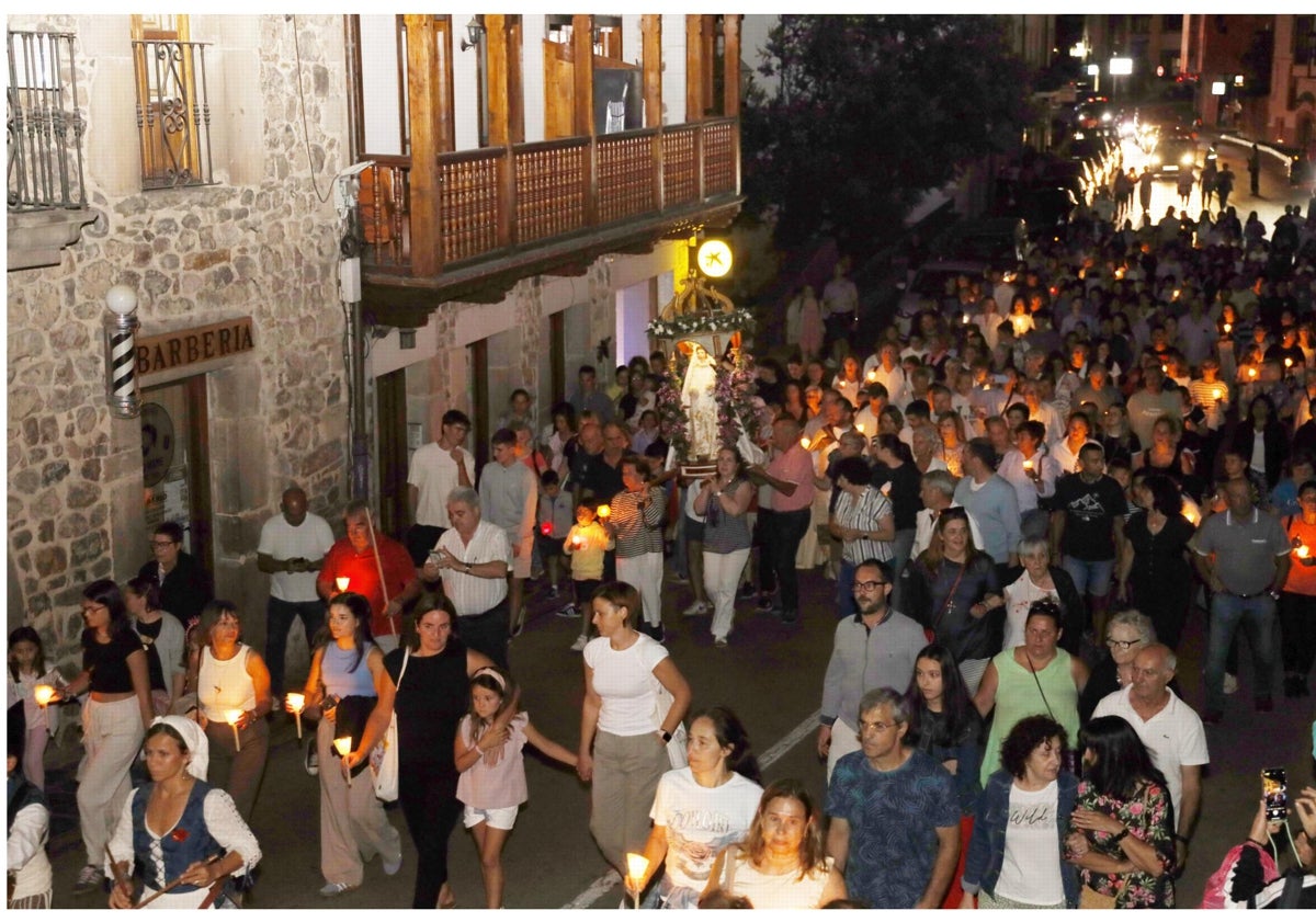 Imagen principal - La procesión a su paso por El Cantón y La Plaza, y dos devotos llevan en andas a la imagen cerca de la iglesia