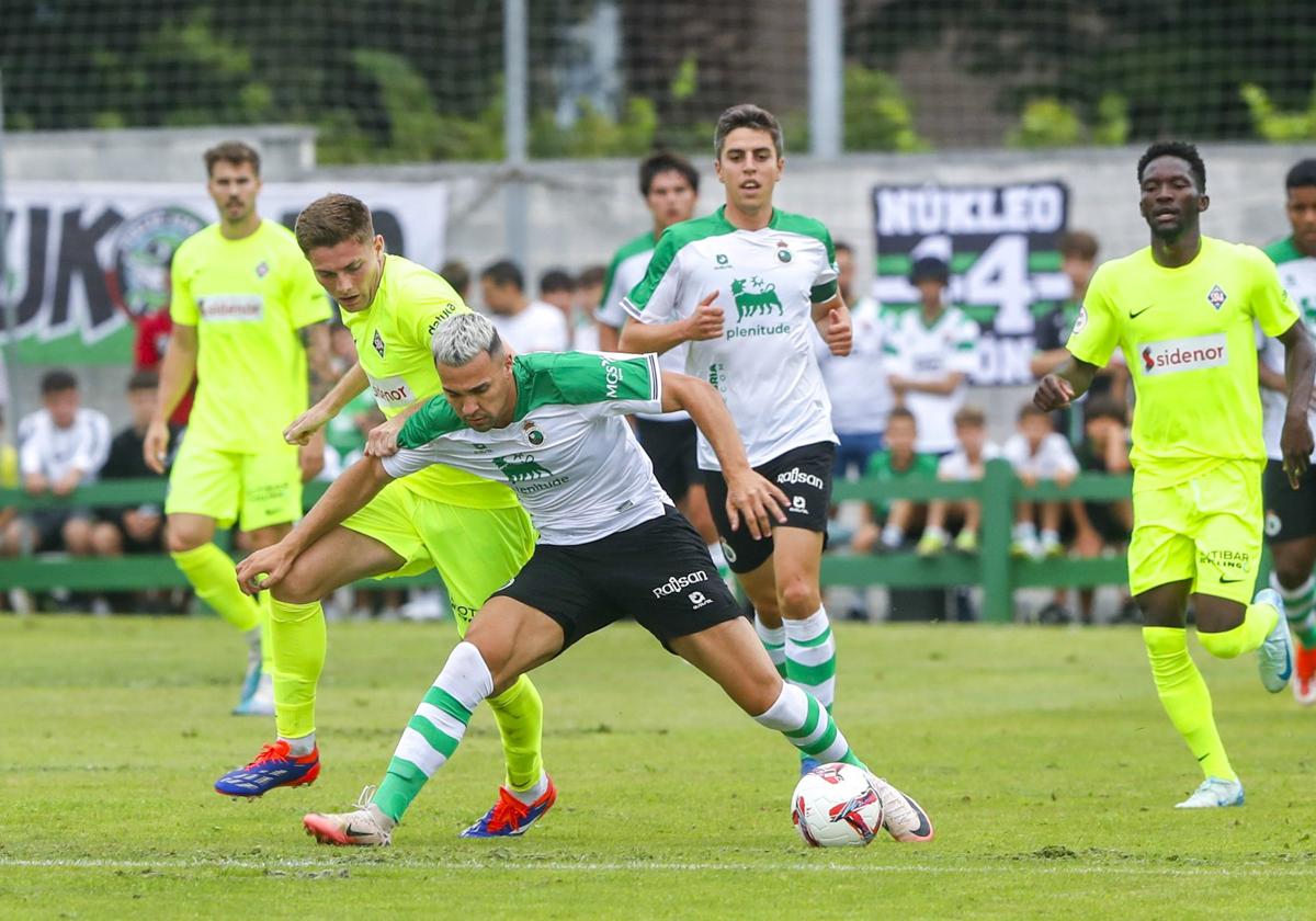 Juan Carlos Arana controla la pelota ante varios rivales del Amorebieta en el partido que se disputó en Guarnizo.