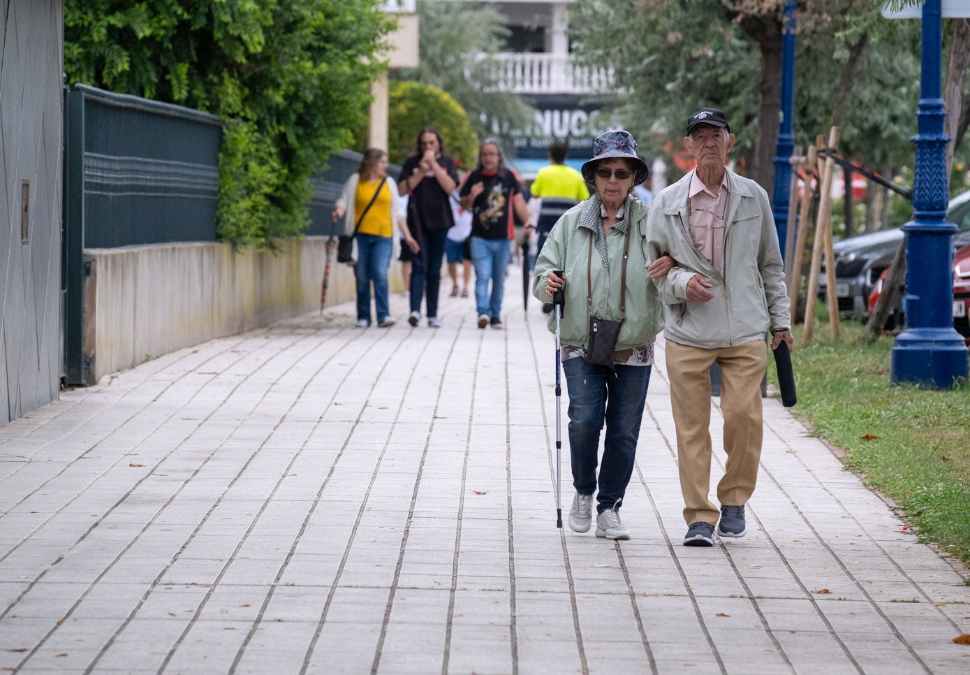 Una pareja pasea, paraguas en mano, en la avenida García lago