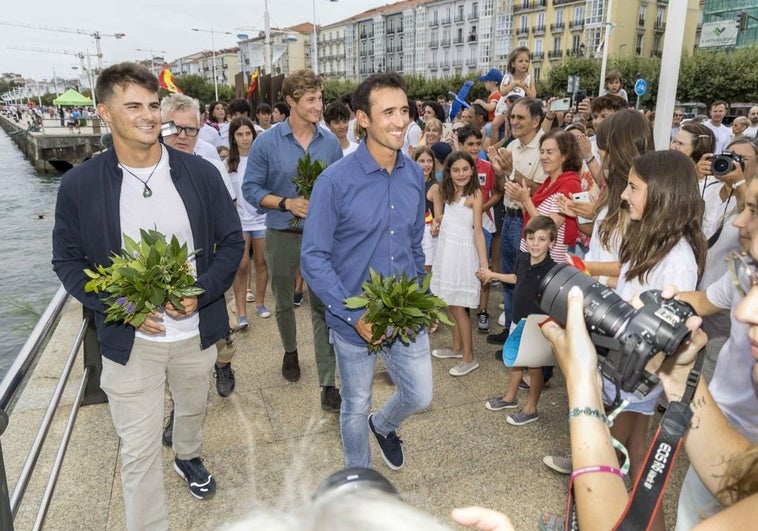 Los campeones, con ramos de laurel, se dirigen hacia el club, donde recibieron su homenaje, guiados por un pasillo de jóvenes regatistas.