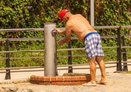 Un hombre se rellena la botella para sobrellevar el calor.