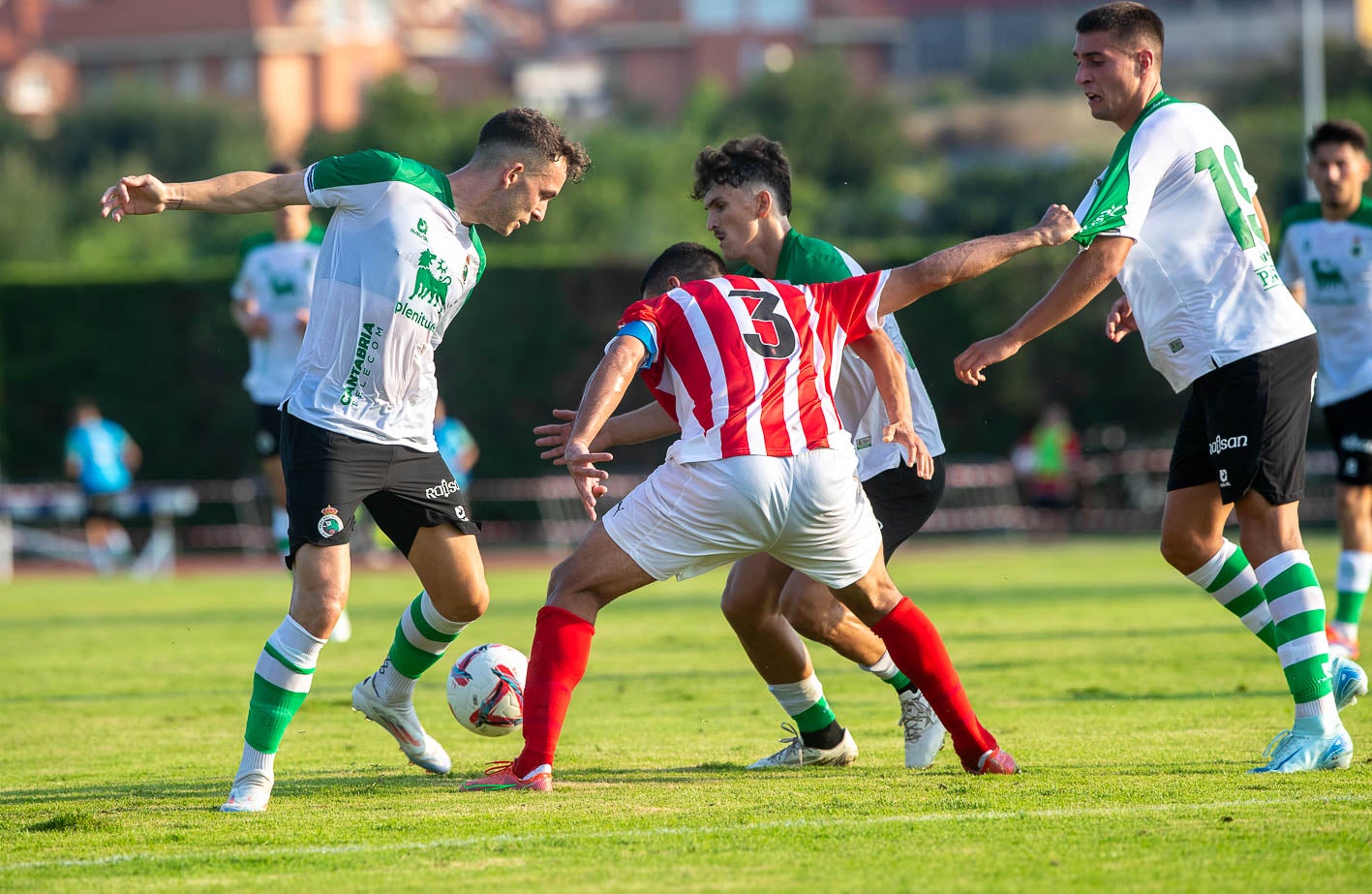 Íñigo Vicente, a la izquierda, trata de controlar el balón mientras Cote, del Sporting acude para quitárselo. 