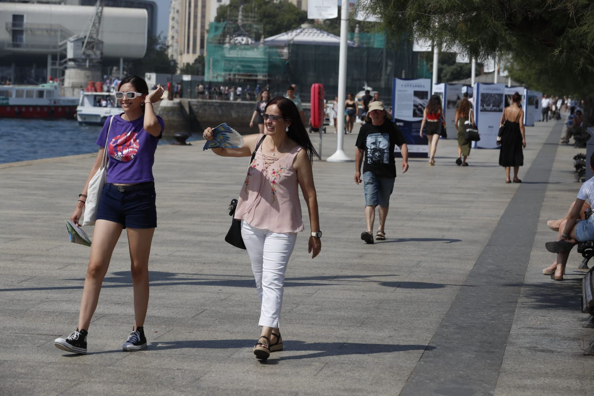 Dos jóvenes pasean por la bahía de Santander. La capital está en aviso rojo por altas temperaturas hasta las nueve de la noche. 