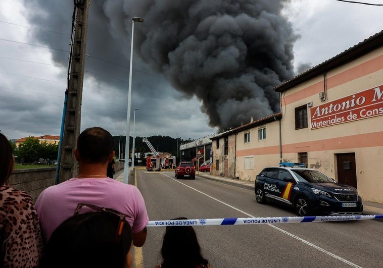 Vecinos asisten al avance de las llamas al otro lado del cordón policial, el viernes, durante el incendio en el bazar oriental.