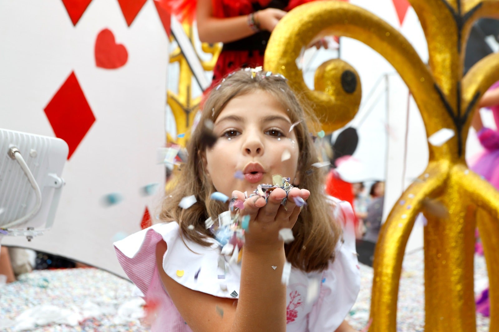 Una de las participantes en la gala sopla un puñado de confeti. 