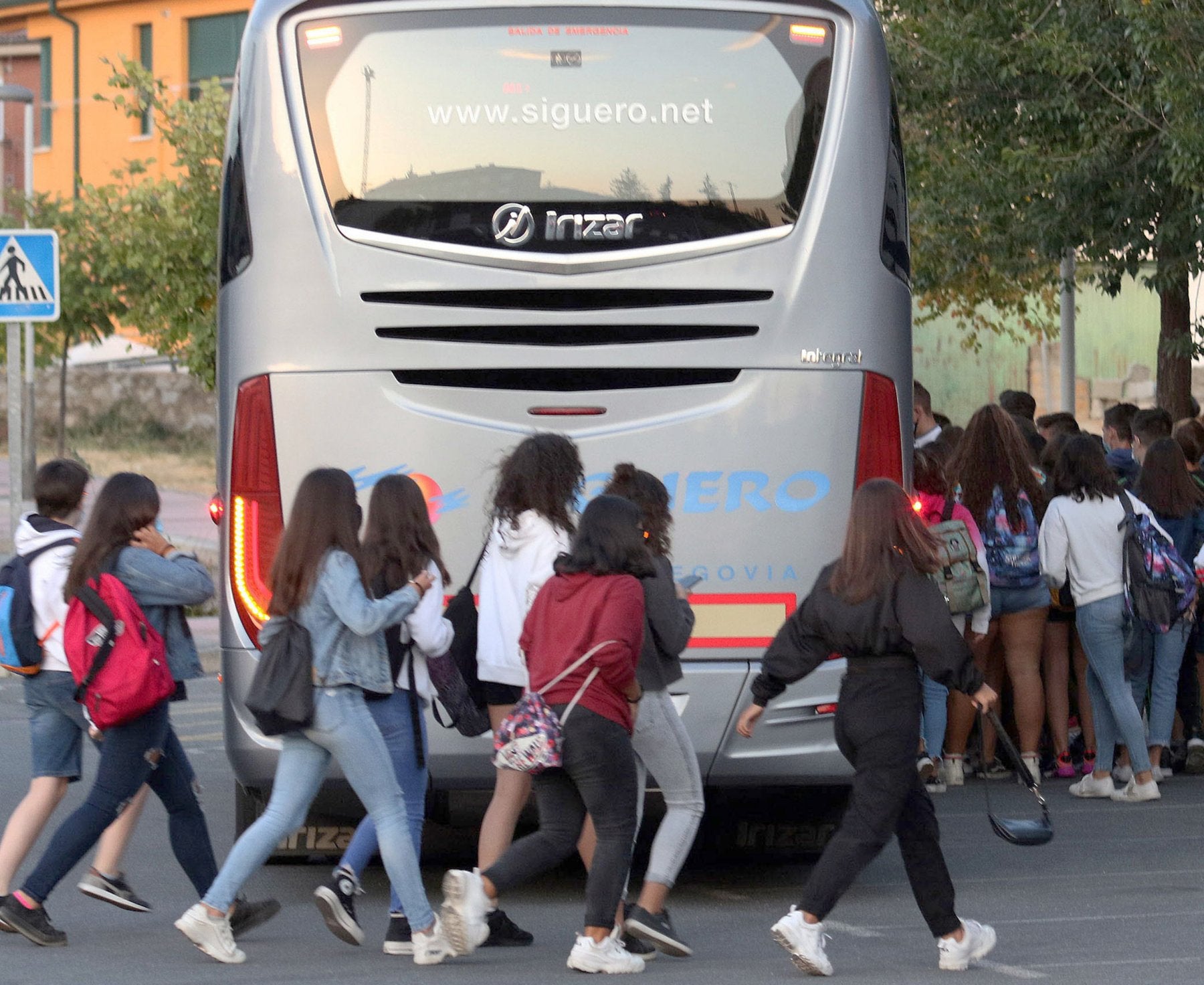 Alumnos subiendo a un autobús dedicado al transporte escolar.