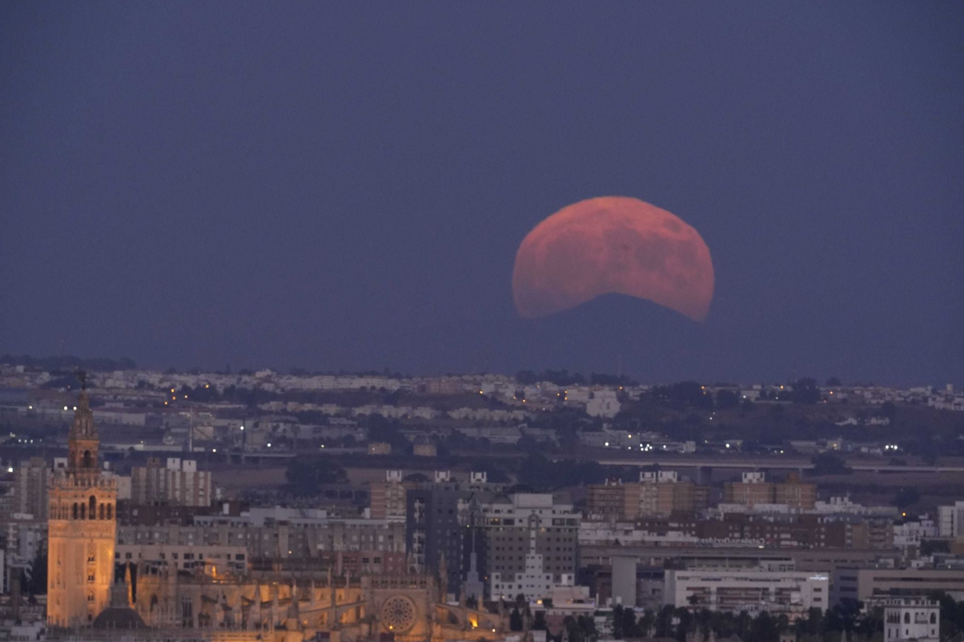 La Superluna del Esturión se ha podido ver de lleno en Sevilla, tras la Catedral y Torre Sevilla.