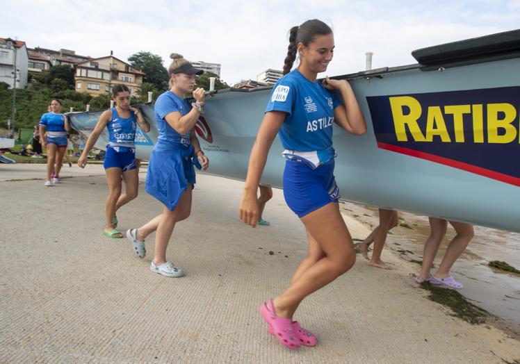 Las azules cargan con la trainera para echarla al agua.