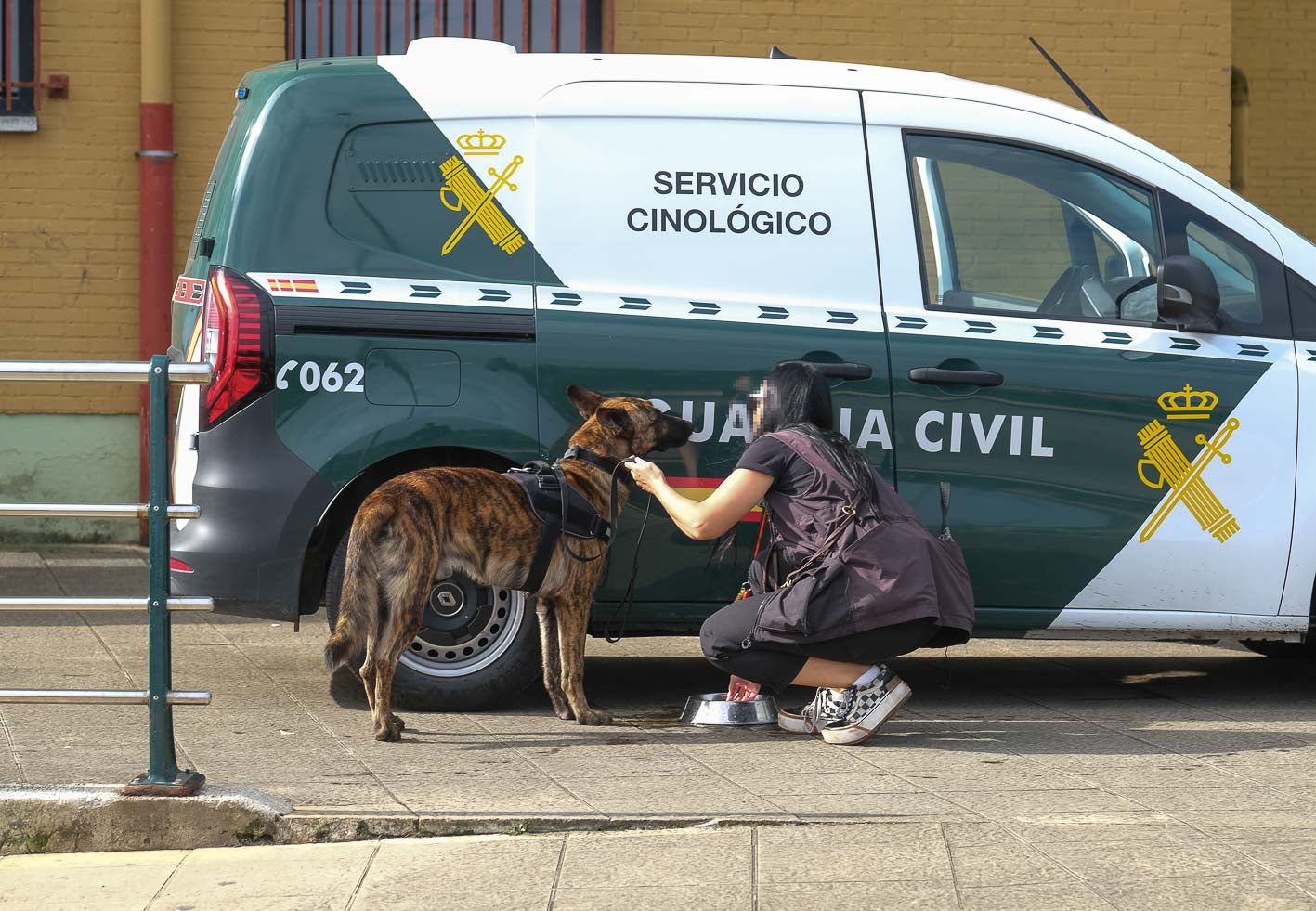 Una agente da de comer a uno de los perros de la Unidad Canina.