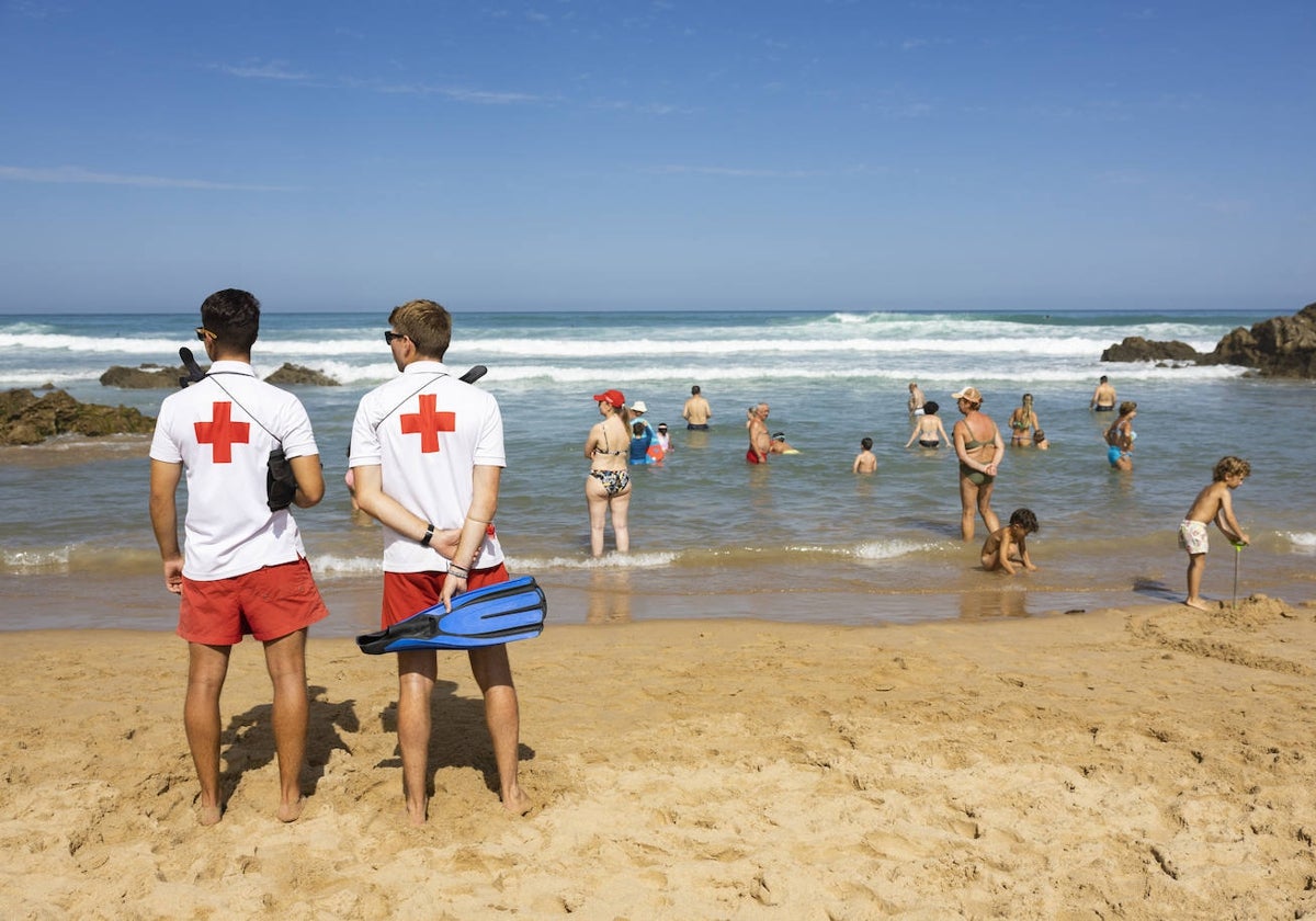 Dos socorristas vigilan la zona de baño en la playa de Liencres, en un día de mar brava.