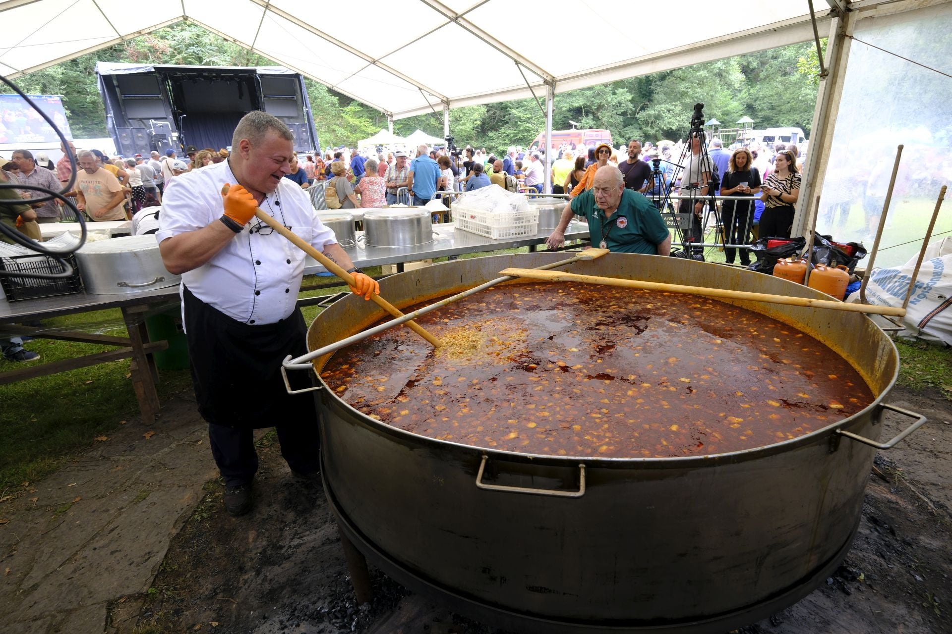 Uno de los cocineros da los últimos toques al guiso.