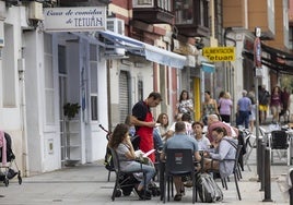 Un camarero atiene una terraza en Santander.