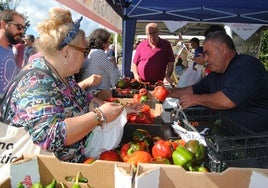 Una mujer comprando los famosos pimientos en uno de los puestos instalados en Isla