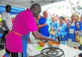 Pescadores del Madre Lita dan a degustar su plato, elaborado con rape, a los vecinos en el puerto.