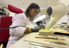 Eva Pereda limpia la vaina del siglo II a.C. en un laboratorio del Museo de Prehistoria de Cantabria (Mupac).