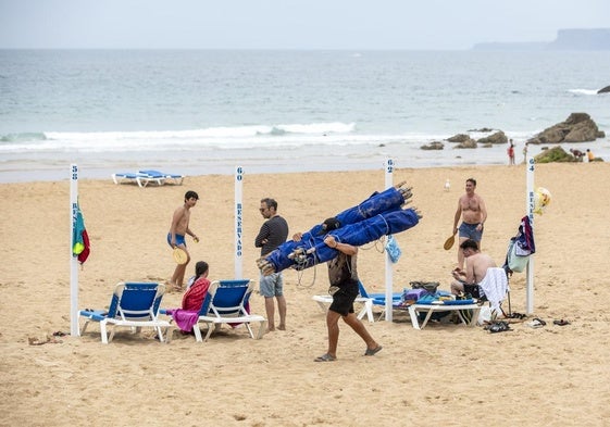 Varios bañistas recogen sus bártulos en la Primera playa de El Sardinero ante la amenaza de lluvia.