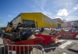 Contenedores llenos con los restos de mobiliario y equipamiento de la nave afectada por el incendio del domingo en Cartes.