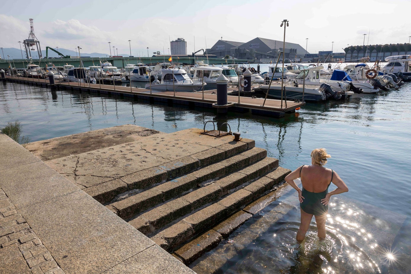 Una mujer aprovecha la altura del agua para darse un chapuzón en el Barrio Pesquero.