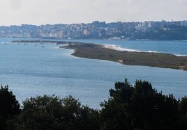 Los vecinos de San Vicente de la Barquera observaban, en el paseo marítimo Antonio Garelly, el aumento del nivel del mar.