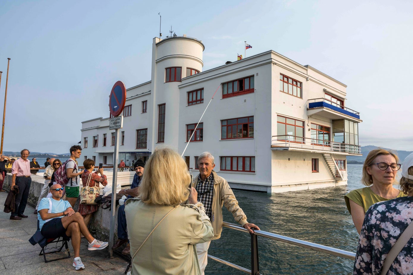 Una mujer toma una foto con el mar de fondo que casi llega a la escalerilla lateral del Marítimo.