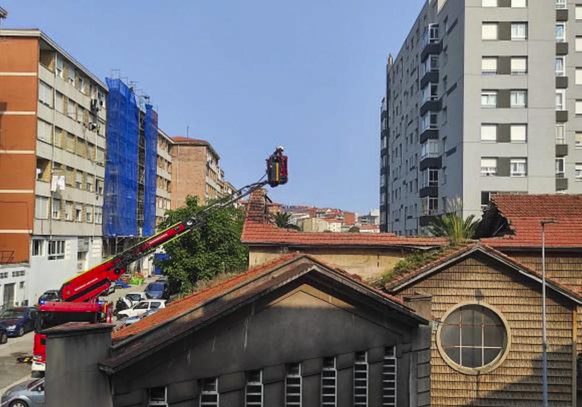 Los bomberos inspeccionan desde las alturas la dimensión del derrumbe del techo de la iglesia.