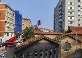 Los bomberos inspeccionan desde las alturas la dimensión del derrumbe del techo de la iglesia.