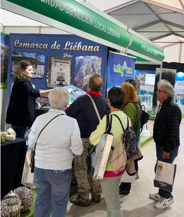 Imagen secundaria 2 - Ganador del sorteo en el stand, materiales de promoción de la comarca y público visitando el stand.