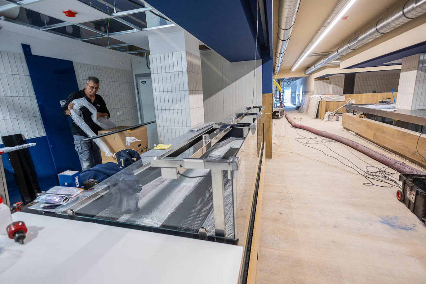 Interior del Mercado de Puertochico, con el suelo acabado en madera clara, también en los seis puestos.