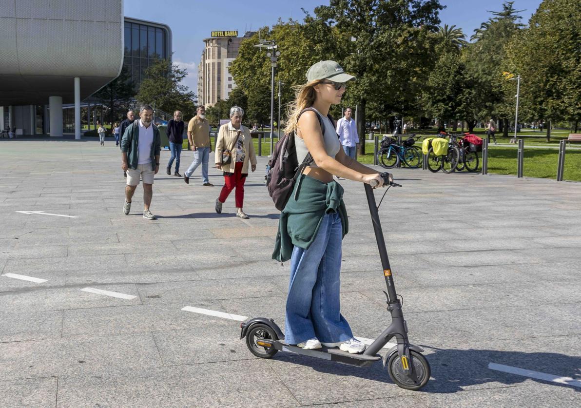 Una joven circula en patinete eléctrico por el paseo marítimo de Santander, junto al Centro Botín.