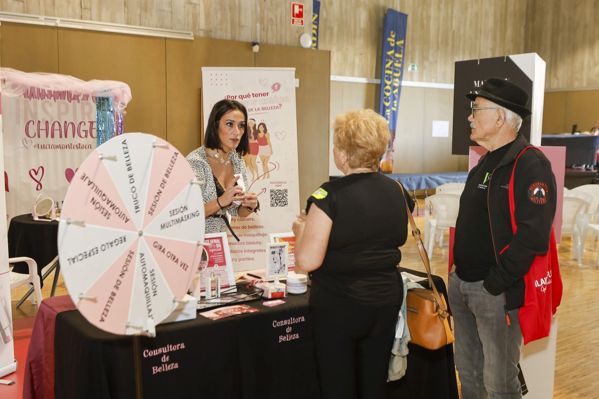 Una de las vendedoras muestra los productos de maquillaje a dos asistentes.