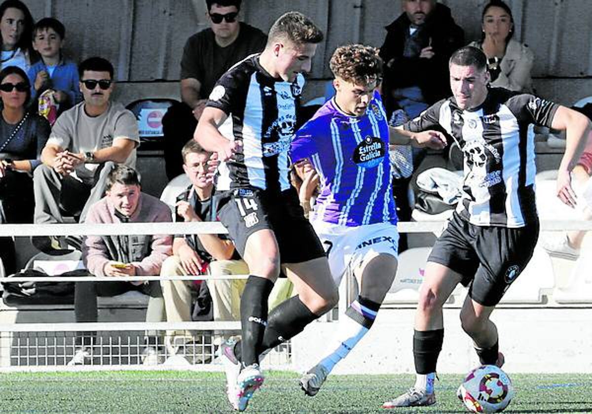 Tresgallo, a la izquierda y  Cagigal,a la derecha, rodean a un jugador del Valladolid