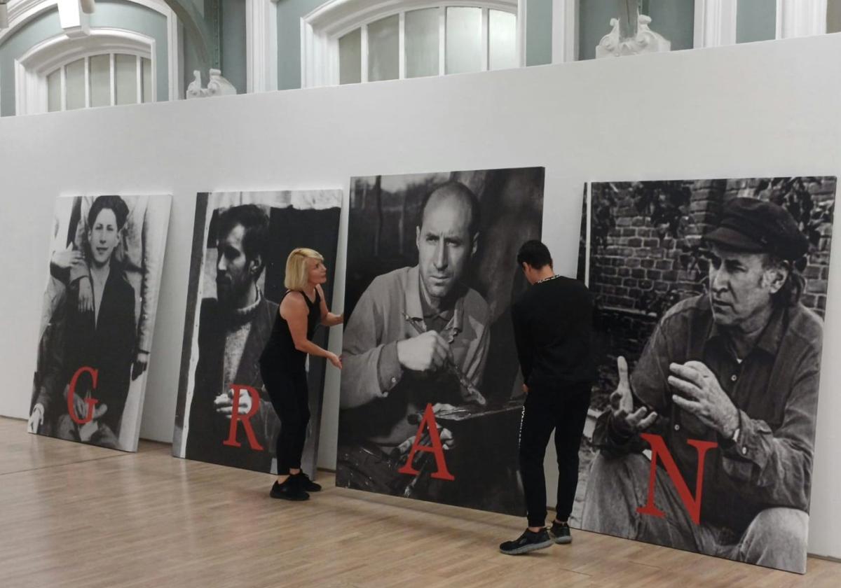 Begoña Merino, presidenta de la Fundación del pintor, participa en el montaje de la muestra. A la derecha, dos de sus obras.