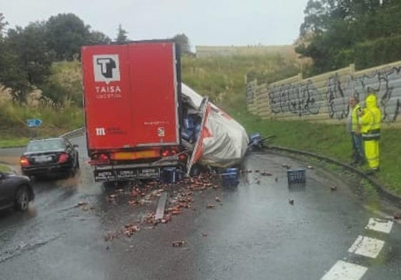 El camión accidentado y la mercancía desparramada por la rotonda.