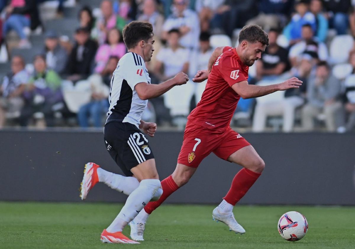 Soberón conduce la pelota mientras un jugador del Burgos trata de frenarlo.