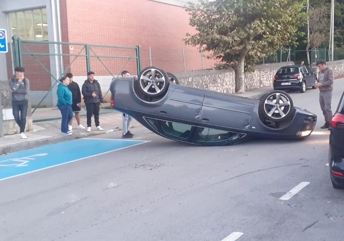 El coche quedó volcado en mitad de la vía.