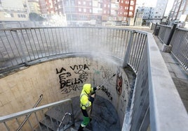 Un trabajador limpia la escalera de acceso a la plaza de La Cepa.