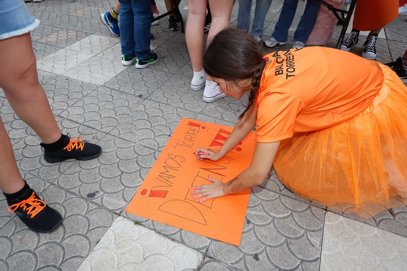 Una aficionada realiza una pancarta de apoyo al equipo.