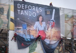 Los activistas de Greenpeace, desplegando la pancarta en la fachada del Paseo Pereda.