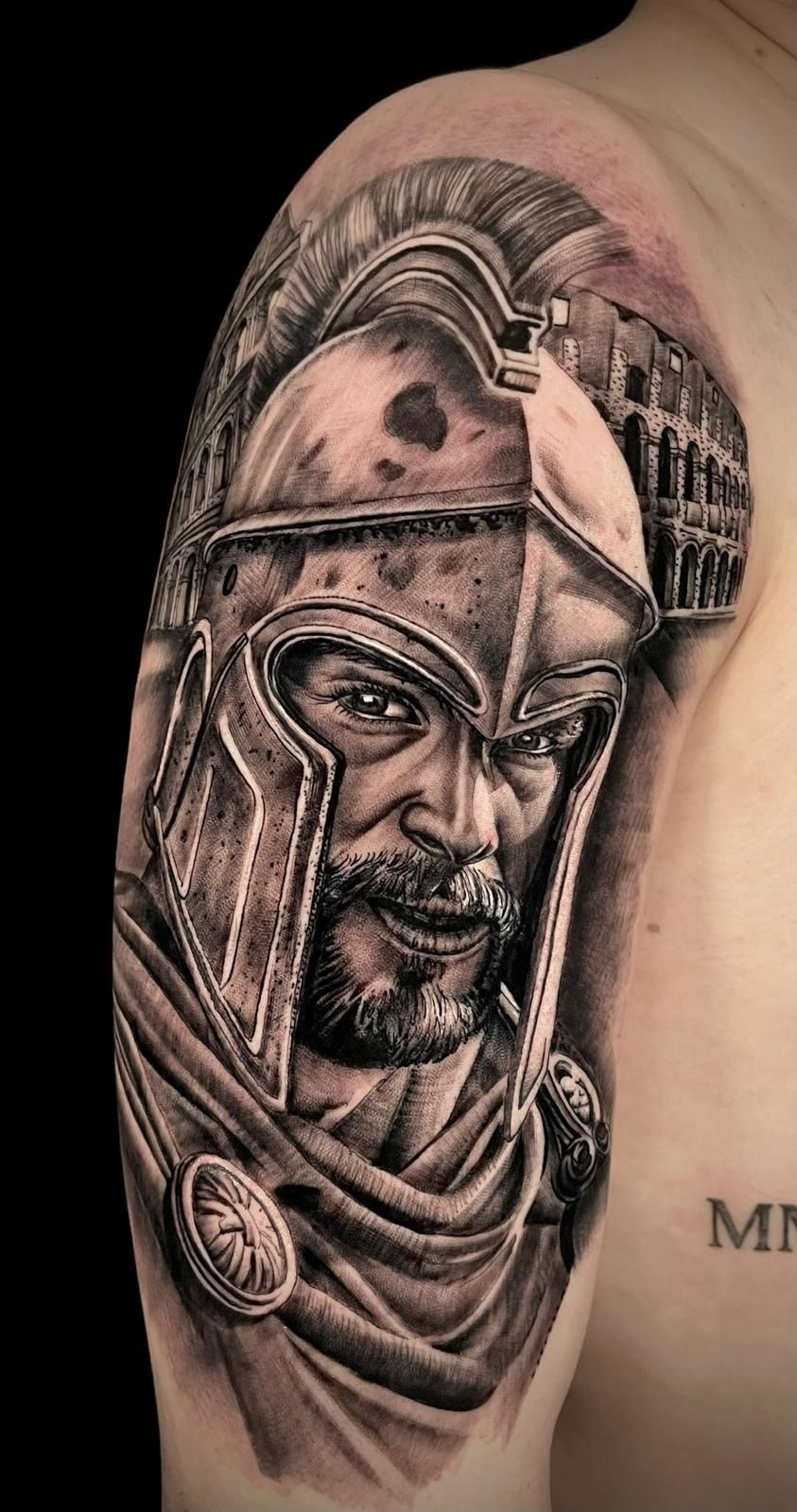 Tatuaje realizado por David Poncela, en el que se observa el retrato de un gladiador romano con el Coliseo de fondo