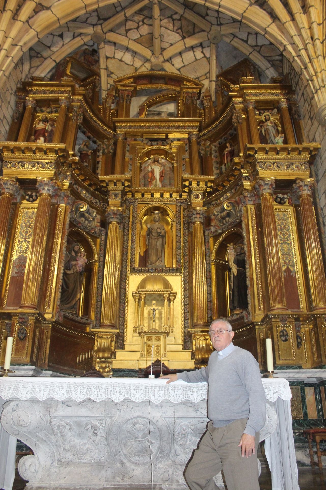 El párroco de Liérganes, Hilario Obregón que teme que cualquier día el retablo mayor ceda y se caiga encima de algún visitante o feligres.