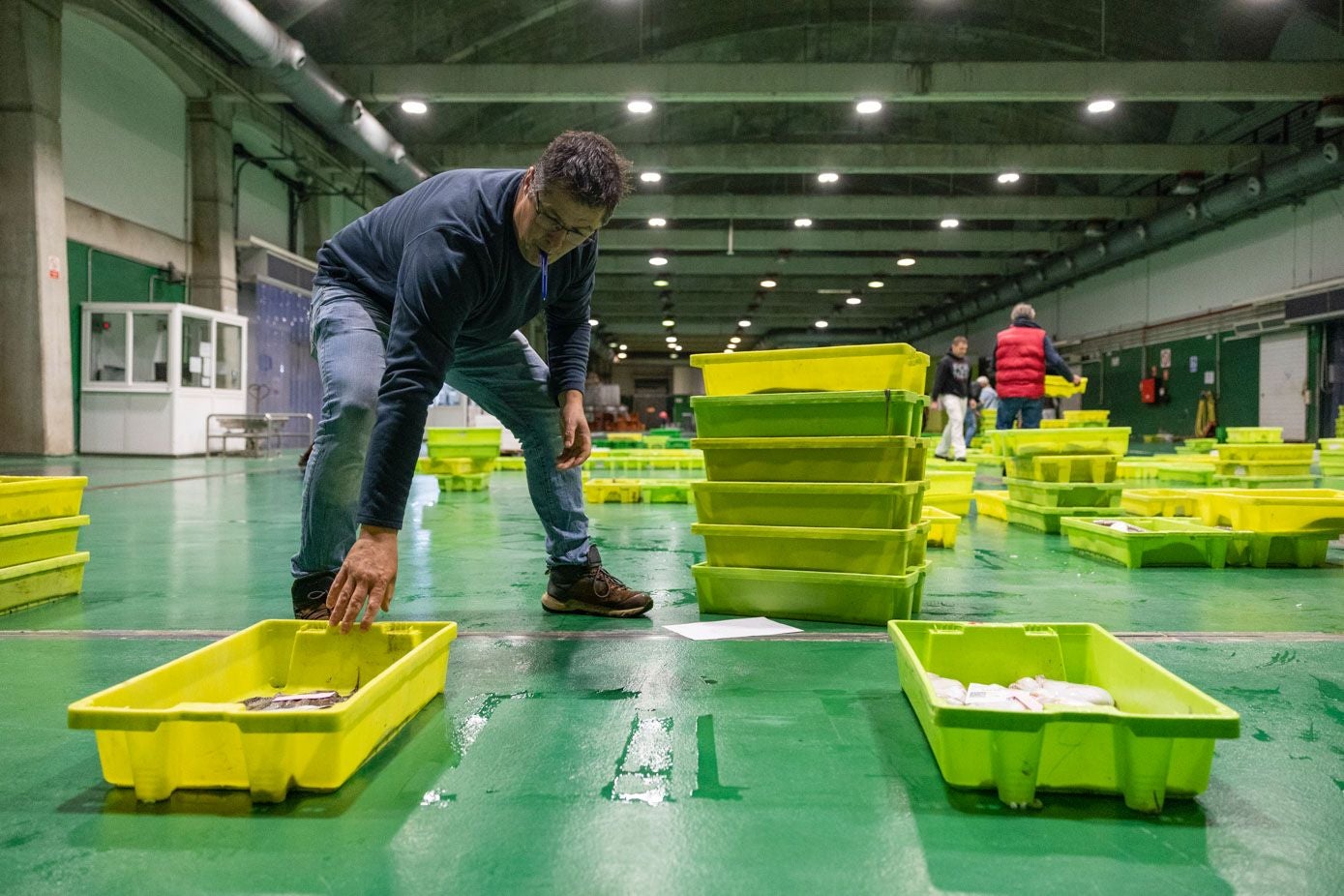 Antes de entrar a la sala de subastas, los compradores examinan el pescado que se encuentra disponible ese día y toman nota de las posibles compras a realizar durante el momento de la puja. En la fotografía, Unai Martín prepara su lista.