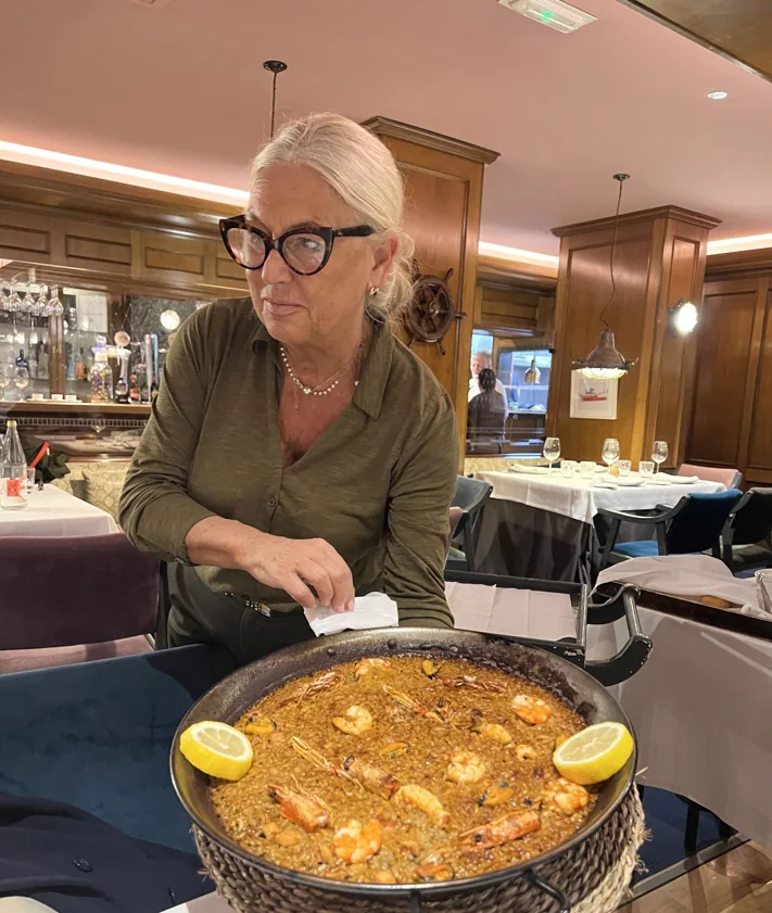 Imagen secundaria 2 - Marián muestra la paella al cliente antes de servir. Arriba, pulpo gallego con fondo y mostaza, y profiteroles de queso de cabra y foie.