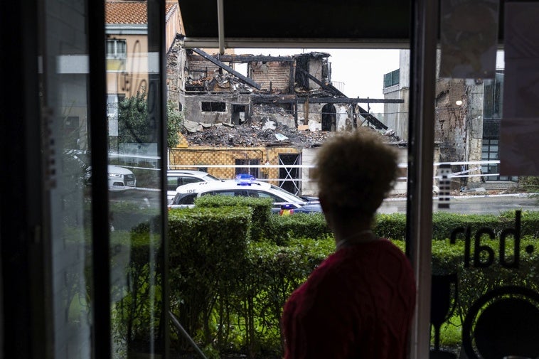 La camarera de una cafetería que se encuentra frente al edificio derrumbado, observa los escombros que quedaron tras el incendio.