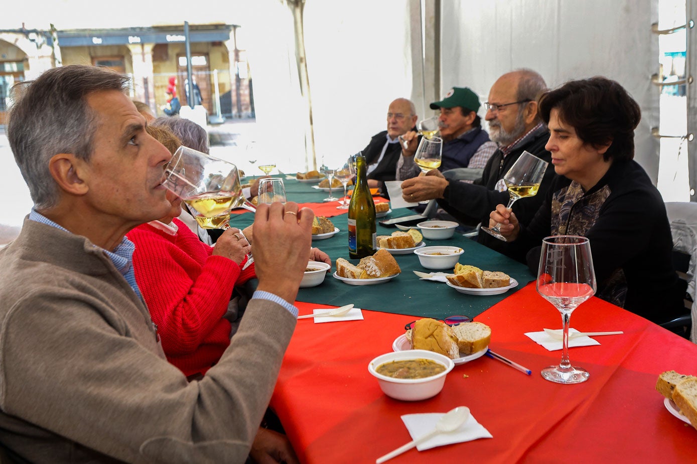 Vecinos disfrutan del vino blanco que acompañó al puchero.