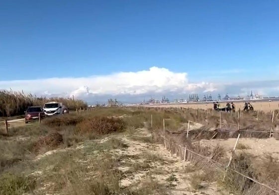 Momento de la recogida del cadáver en la playa de El Saler.