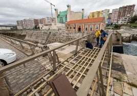 Varios operarios de los talleres municipales, ayer, trabajan en la pasarela peatonal de Gamazo, clausurada actualmente.