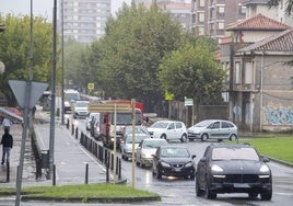 Vehículos circulan lentamente por el Paseo de Julio Hauzeur y la rotonda ovalada, junto al IES Miguel Herrero, en Torrelavega.