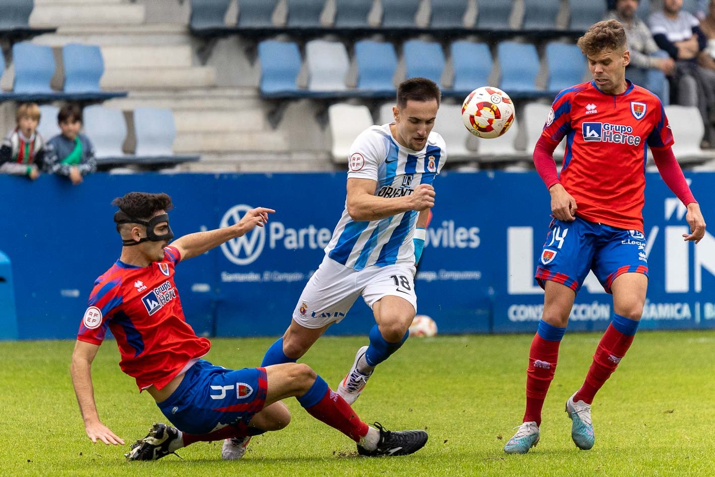 Chus Ruiz se lleva el balón ante los jugadores del Numancia Lucas Laso (izquierda) y David Sanz.