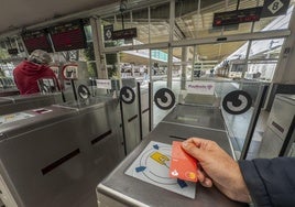 Un usuario pasa la tarjeta bancaria sin contacto por el torno.Una viajera paga ayer con la tarjeta bancaria sin contacto en los tornos de la estación de tren de Santander.